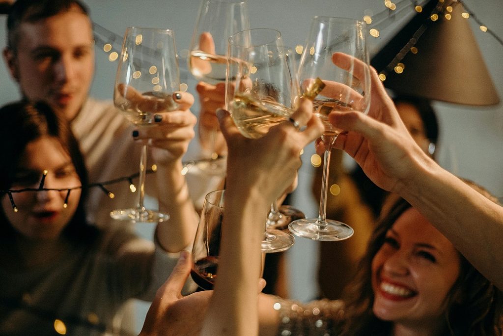 Muchas manos alzando sus copas en un brindis