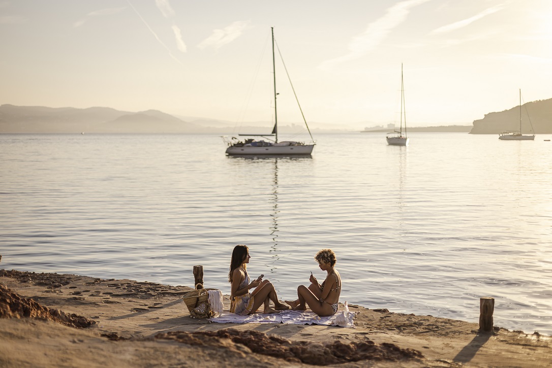 2 amigas relajadas en el orilla de Cala Bassa